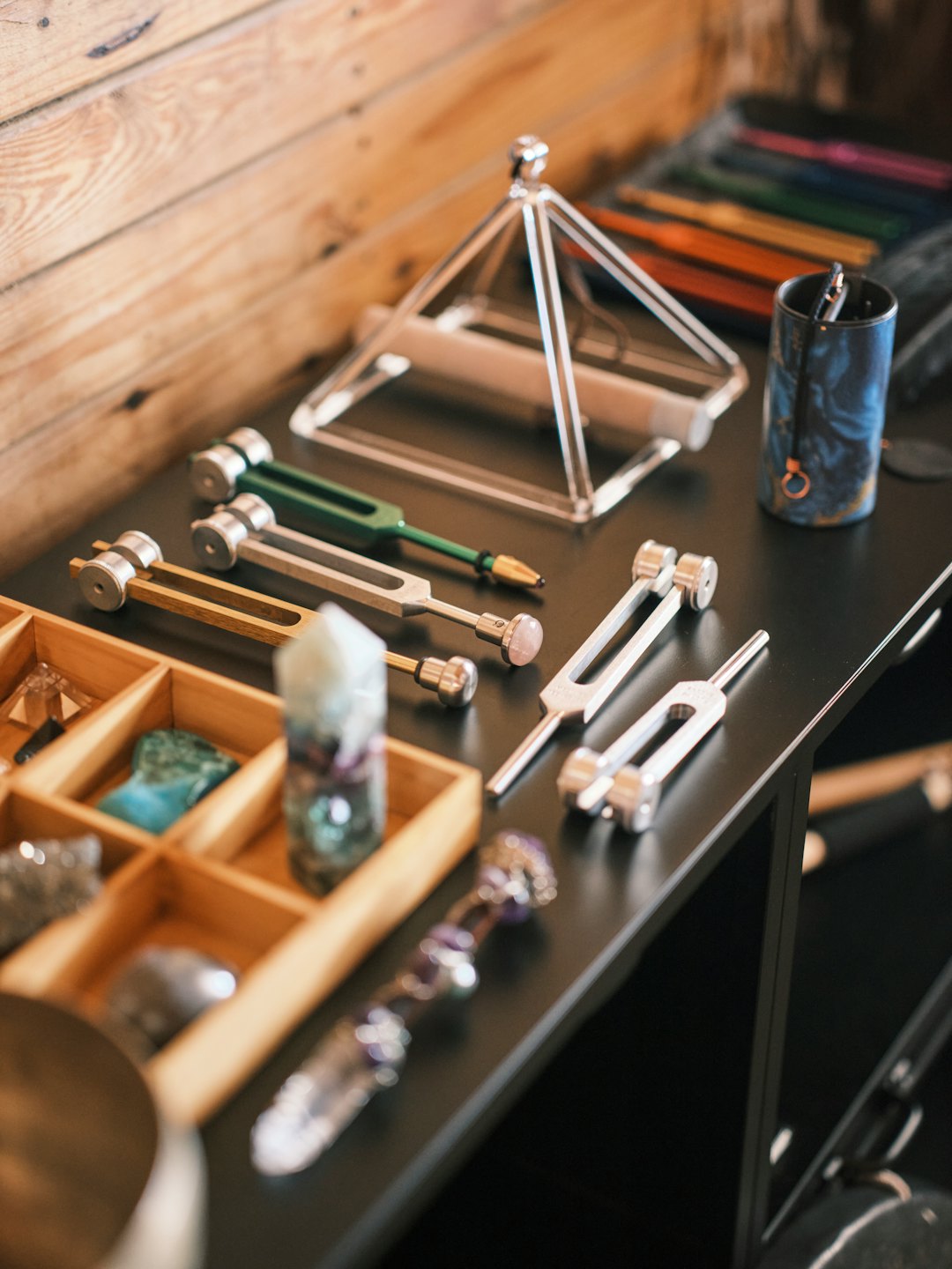 Tuning forks and healing crystals arranged on a wooden table.